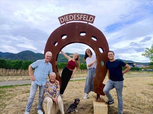 Matthias, Marianne und Nicole Ehmer mit Theresa und Daniel Hoefer und Hund Dori vor dem Hufeisen-Denkmal „Diedesfeld“ in den Weinbergen